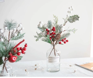 Christmas bouquet detail with red berries pine cones and frosted snowballs in a glass vase