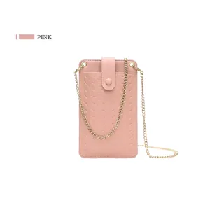 Detailed view of pink woven leather phone bag with gold chain strap and snap closure