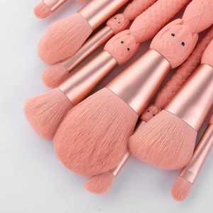 Close-up of pink mermaid makeup brushes featuring detailed dragon scales relief handles