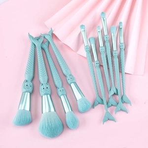Detail of 11-piece mermaid tail makeup brushes with teal scales and soft synthetic bristles