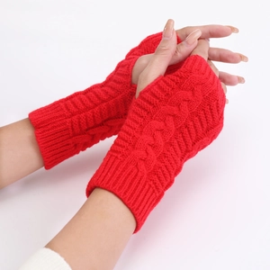 Detail of red cable-knit fingerless gloves showing warm textured wool fabric