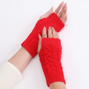 Close-up of red cable knit fingerless gloves showing elastic texture and soft wool material