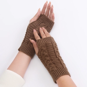 Close-up of brown cable-knit fingerless gloves showing soft wool texture and patterns