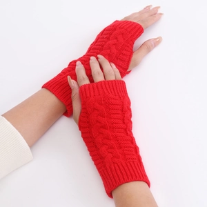 Detail of red cable knit arm warmers with thumb holes showing the soft texture and pattern