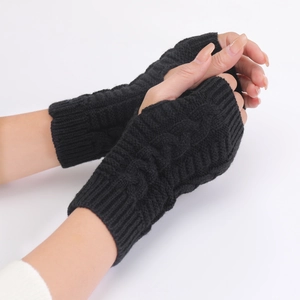 Detail view of black cable-knit fingerless gloves showing texture and wrist length