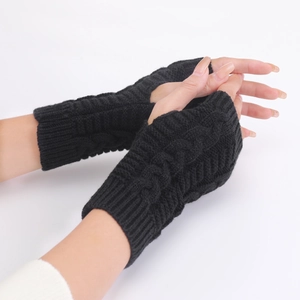 Detail of black cable-knit fingerless gloves showing high-quality acrylic yarn texture