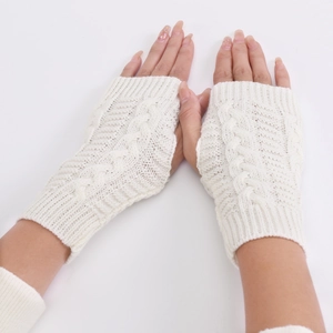 Detail of cream cable knit fingerless gloves showing thick texture and elastic cuffs