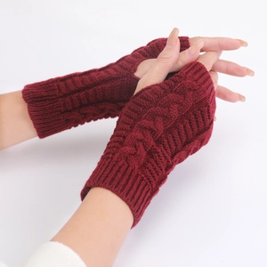 Detail of wine red cable knit fingerless gloves showing texture and wrist fit