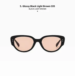 Front view detail of narrow cat eye sunglasses with glossy black frame and light brown lenses
