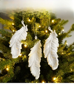 Close-up of white glitter feather Christmas tree ornaments with silver hanging strings