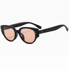 Cat-eye sunglasses detail with orange lenses and silver rivets on a black frame