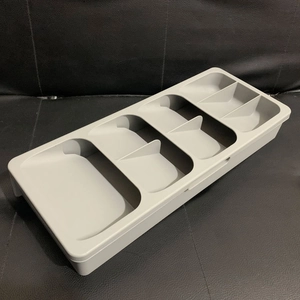 Detailed view of grey drawer organizer with five compartments for cutlery storage