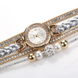 Macrodetail van luxe dameshorloge met strass-steentjes, parels en gevlochten bandjes