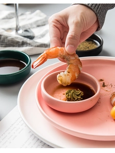 Close-up of pink ceramic dipping bowl being used with a shrimp in a lifestyle setting