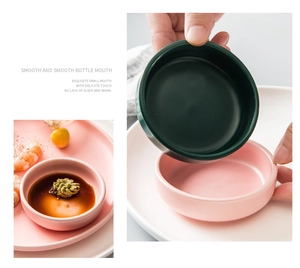 Close-up of matte ceramic sauce dipping bowls in pink and green with smooth round edges