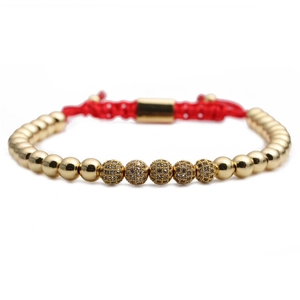 Close-up of red braided rope bracelet with 4mm gold beads and sparkling crystal charms