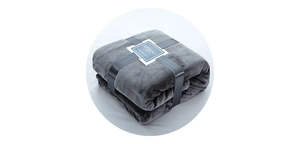 Folded dark grey flannel blanket with elegant black ribbon packaging and gift label