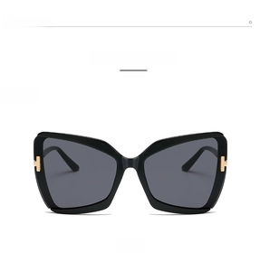 Detailed front view of black butterfly sunglasses with gold T-shaped metal accent