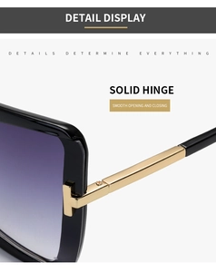 Detailed close-up of golden T-shape hinge and purple gradient lenses on black sunglasses