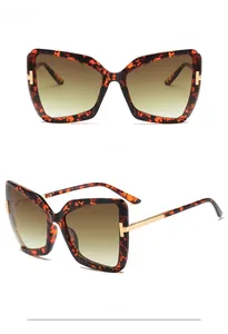 Detail view of tortoiseshell butterfly sunglasses with signature golden T-hinge accents