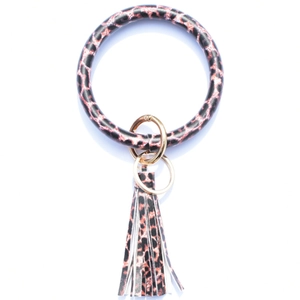 Macro view of leopard print leather O-ring bracelet with pink fringe and gold keychain