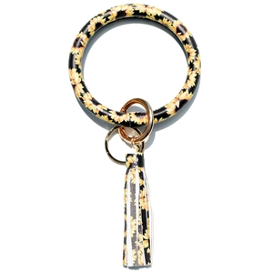 Detail of sunflower pattern leather wristlet keychain with golden ring and tassel