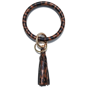 Detail of leopard print leather bangle keychain with golden metal clasp and long tassel
