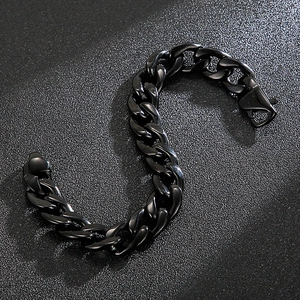 Macro shot of 18K gold plated black Cuban link bracelet with lobster clasp on dark background