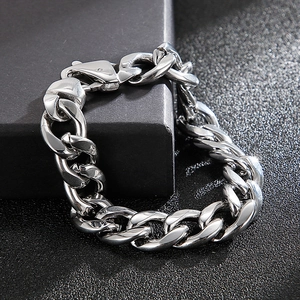 Detail of silver titanium steel curb chain bracelet with lobster clasp on dark texture