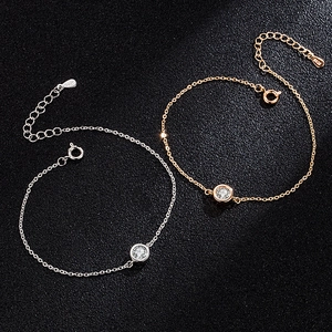 Moissanite bubble bracelets in silver and rose gold finishes on black textured background