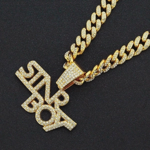 Iced-out gold Cuban link necklace featuring a crystal encrusted SUPER BOY pendant