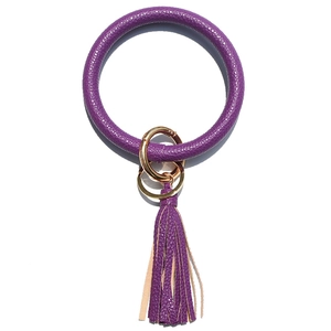 Detail of purple faux leather wristlet keychain with gold metal ring and tassel charm