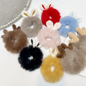 Flat lay of soft plush hair scrunchies with bunny ears and reindeer antlers in diverse colors