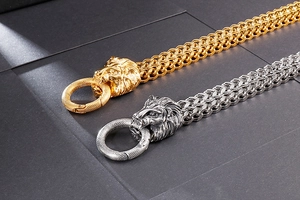 Detail of heavy metal lion head clasp on gold and silver woven chains for men