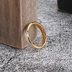 Detailed macro view of brushed silver and gold two-tone stainless steel ring with zircons