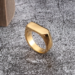Detail of a golden men's stainless steel signet ring with polished and brushed finish
