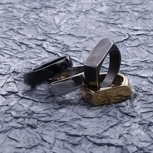 Detail view of geometric stainless steel rings in gold, silver and black finishes