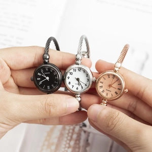 Detailed view of women's quartz bangle watches in black, silver, and rose gold finishes