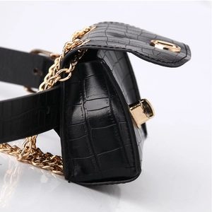 Detail view of mini black crocodile embossed waist bag with elegant gold twist lock and chain
