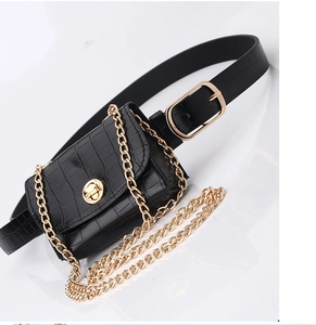 Detail of black crocodile texture waist bag with gold chain on white background