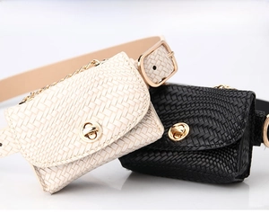 Detailed close-up of mini woven belt bags in white and black with gold metal twist locks