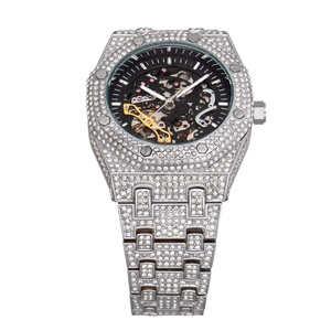 Macro shot of silver skeleton dial watch with sparkling diamonds on the bezel and strap