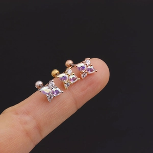 Close-up of star and butterfly cartilage studs in silver, gold, and rose gold finish