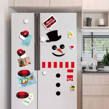 Close-up of Christmas snowman magnetic stickers including hat and scarf on a fridge