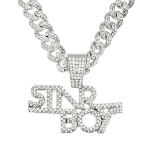 Macro detail of silver iced out Cuban chain with SINR BOY letter pendant and diamonds
