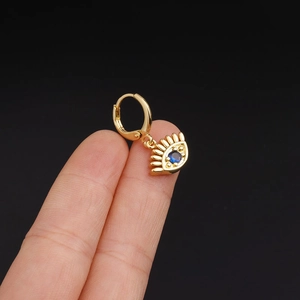 Golden eye-shaped hoop earring with a blue zircon stone shown held by hand