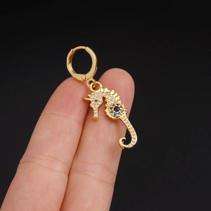 Minimalist gold seahorse drop earring featuring sparkling blue and clear cubic zirconia stones