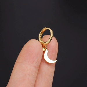 Macro shot of gold moon-shaped ear cuff with pave zircon stones worn on the earlobe