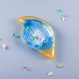 Detail of seashell resin tray featuring blue and gold gradient with gold foil accents