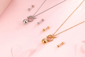 Close-up of elegant gold and silver jewelry sets with OT buckle necklaces and ball earrings
